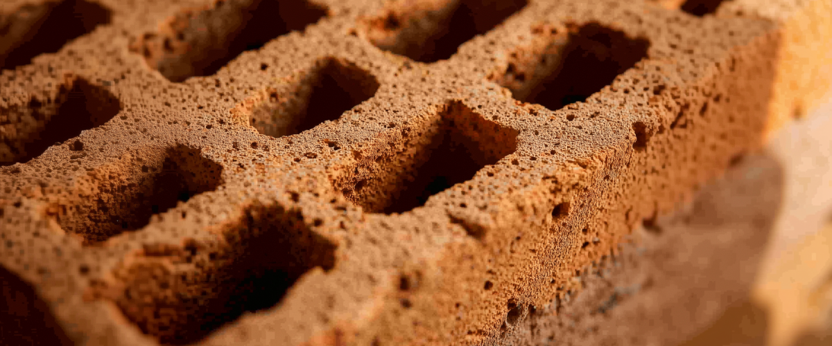 KI-generiertes Bild: Nahaufnahme eines porösen Ziegelsteins mit Strukturdetails, ideal zur Dämmung und für den Brandschutz im modernen Hausbau